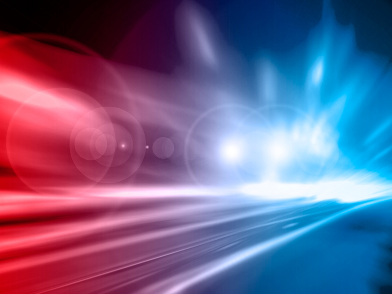 Ein abstraktes Bild zeigt verschwommene rote und blaue Lichtstreifen, die Bewegung darstellen.