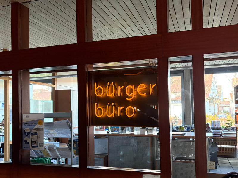 Ein Glaskorridor zeigt von innen den Schriftzug "bürger büro" in leuchtenden Buchstaben.